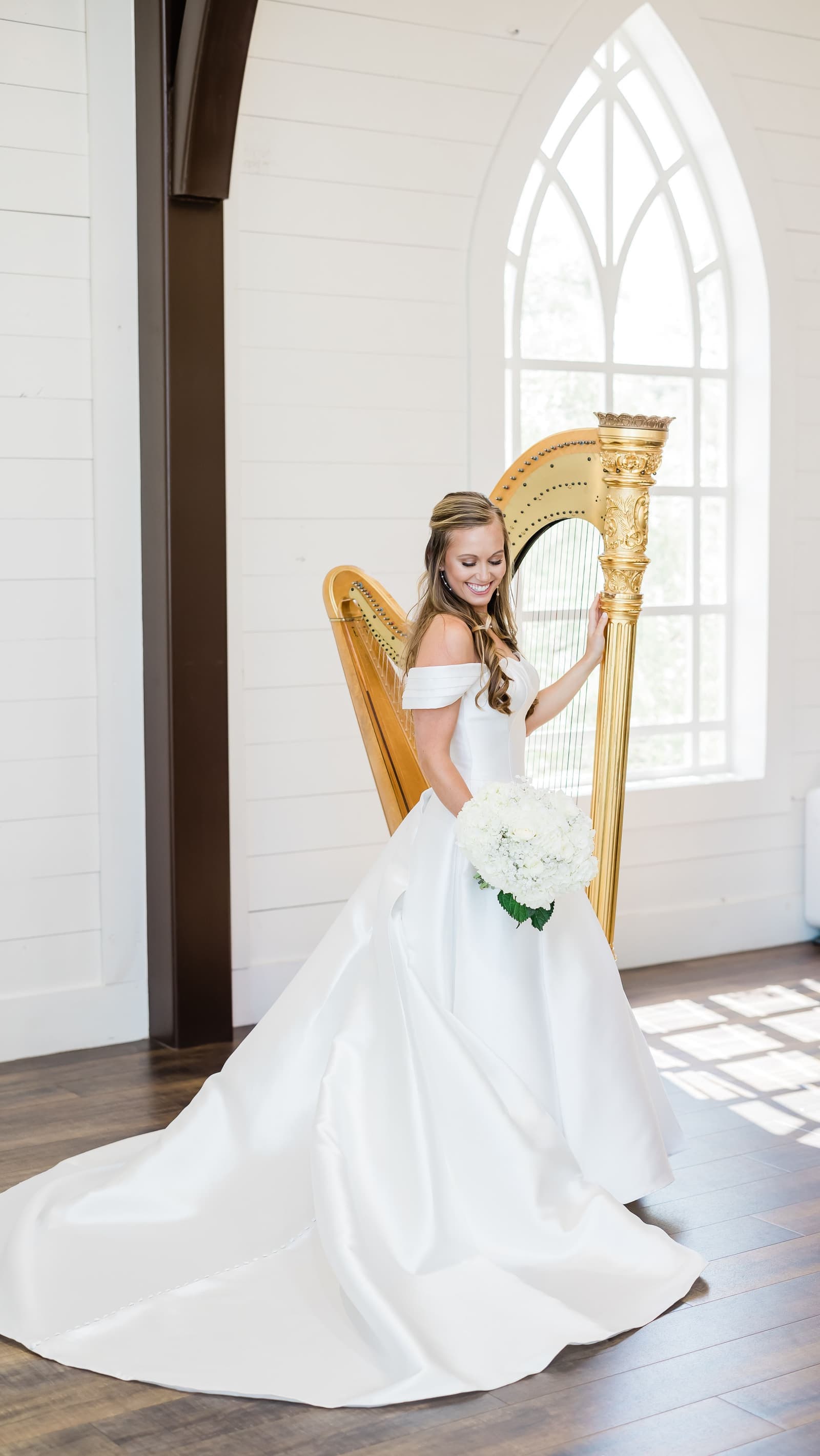 Grace with her harp beside a gothic arched chapel window