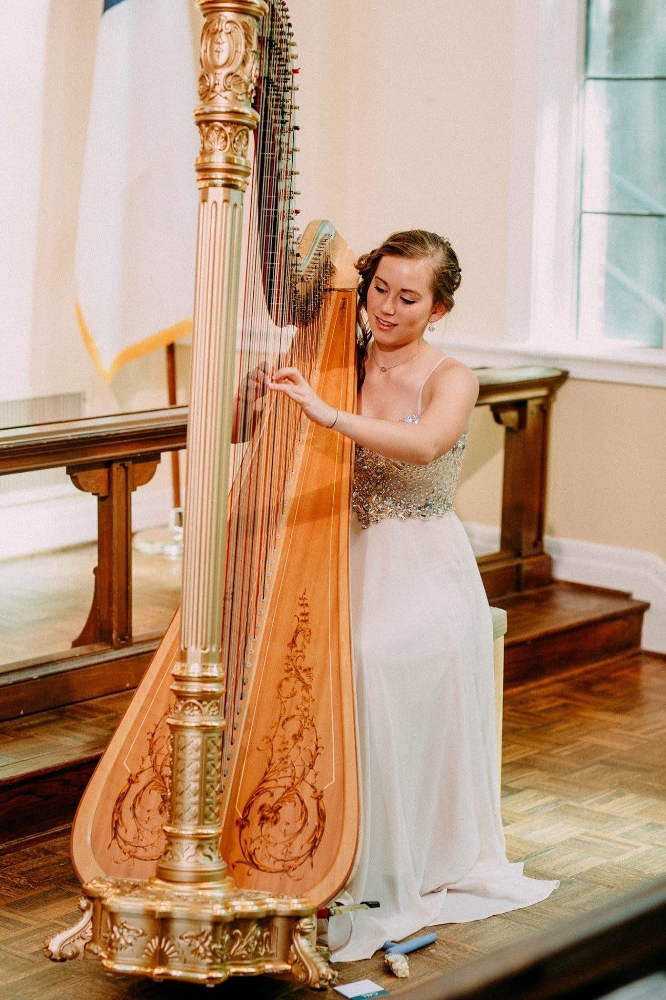 Grace performing on an ornate gold harp in a formal setting